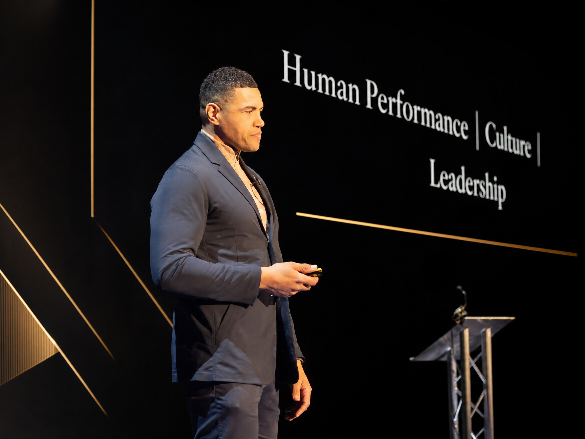 Luther Burrell speaking on stage about Human Performance, Culture and Leadership